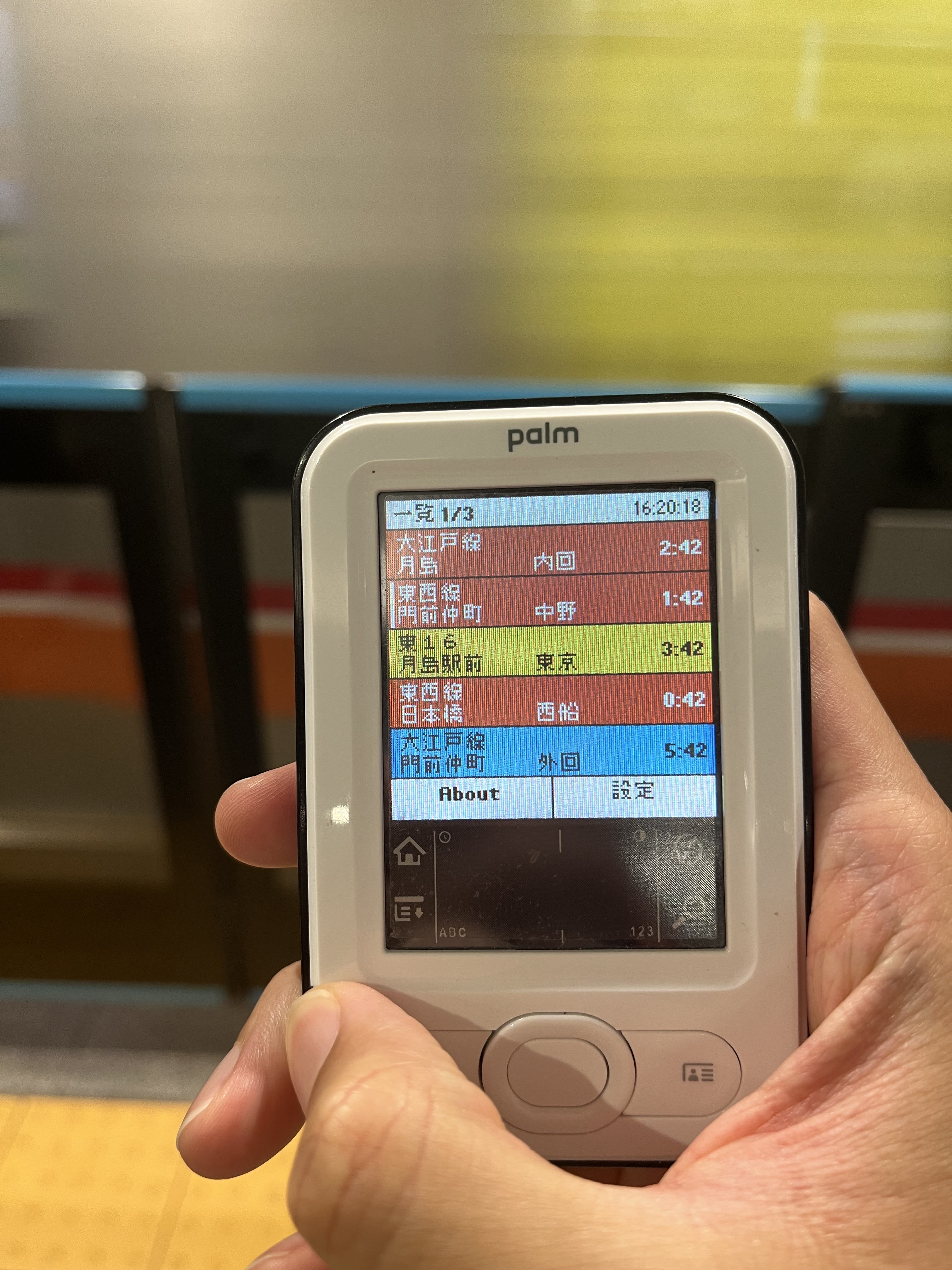 電車内で東京乗換隊を表示したPalmを手に持つ
